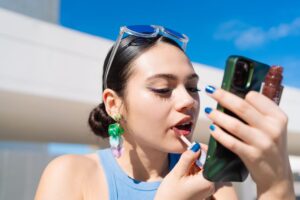 Young Gen Z woman applying make up as part of her beauty routine