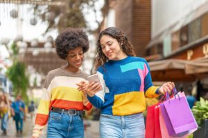 Two young women comparing shopping choices